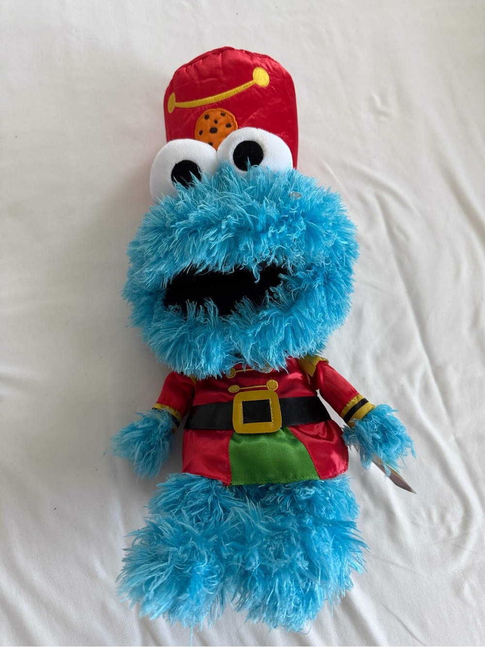 Sesame Street blue plush with red satin sleeve and yellow tag
